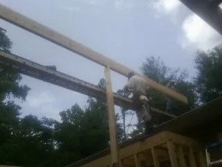 Carpenter setting a ridge beam over a new addition frame — Ice Dam Removal by Roofing Brothers in White Sulphur Springs